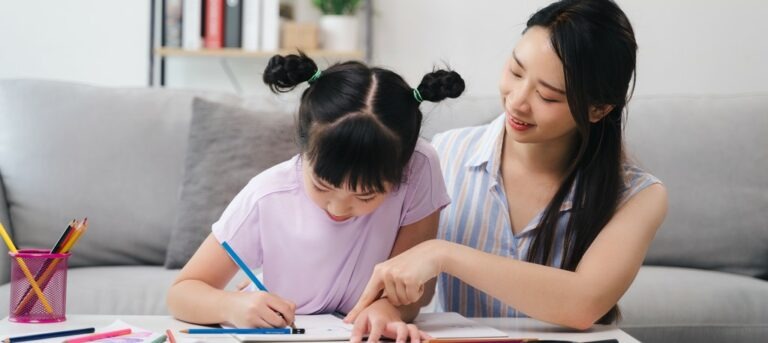 Une mère aide sa fille avec les devoirs, dans le calme.