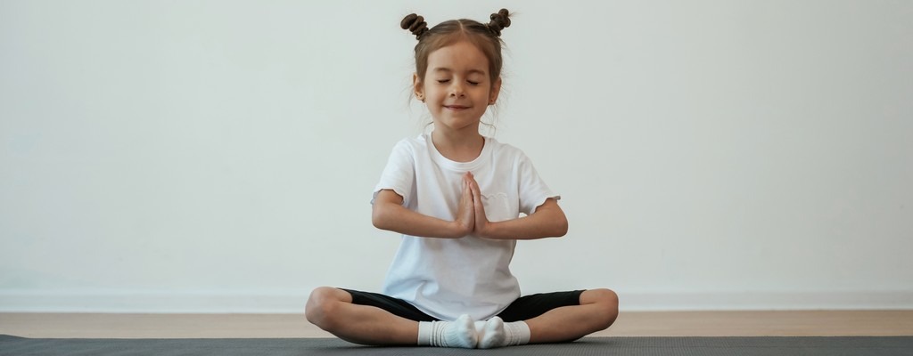 une jeune fille assise en tailleur se détend