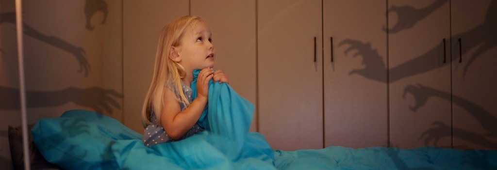 une enfant dans son lit qui a peur