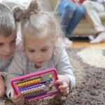Une famille dans un salon avec un enfant utilisant une tablette, et une activité sans écran.