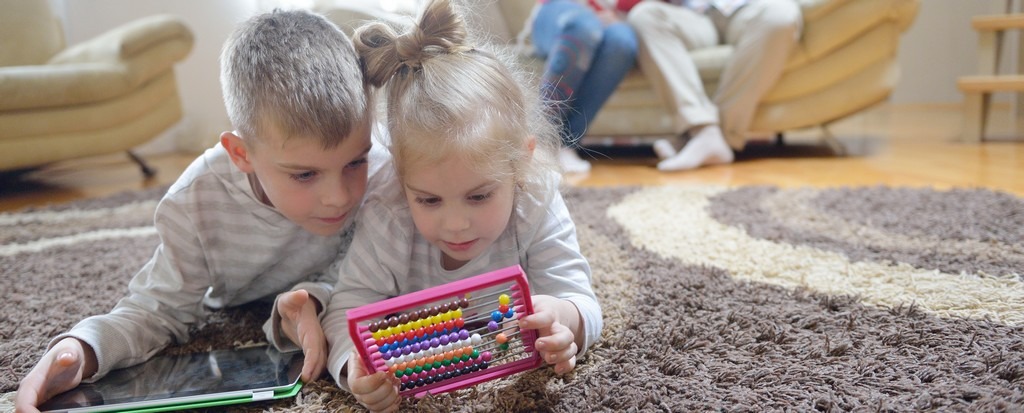 Une famille dans un salon avec un enfant utilisant une tablette, et une activité sans écran.