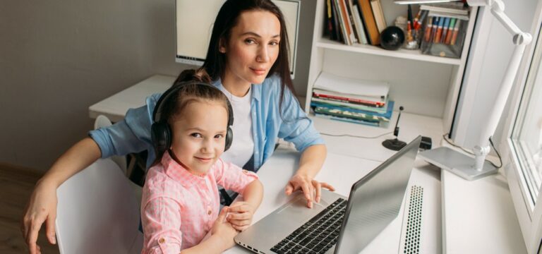 un enfant devant un écran avec un parent à côté, qui regarde les paramètres avec lui.