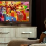 une jeune fille dans un fauteuil regarde une série colorée