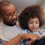 un père et son enfant, sérieux, devant la tablette