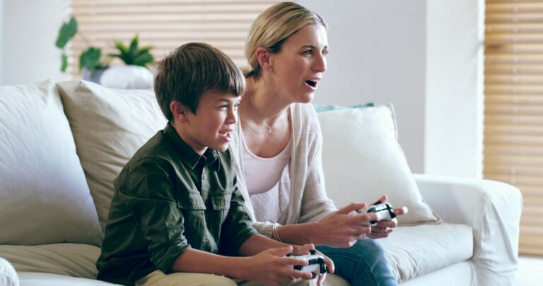 une mère et son fils jouent a un jeu vidéo dans le salon