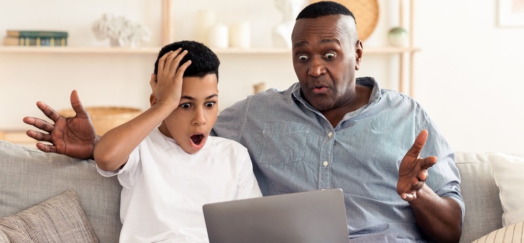 un parent et son enfant, choqués devant le contenu présent sur l'ordinateur