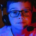 un enfant avec un micro casque devant un stream de jeu vidéo
