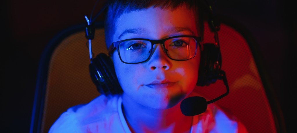 un enfant avec un micro casque devant un stream de jeu vidéo